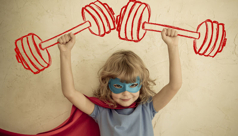 A child wearing a red cape and a blue eye mask